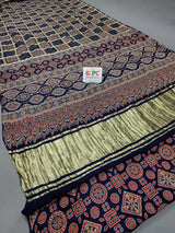 A navy and gold saree with geometric and floral patterns, featuring a central gaji (tassel) design.