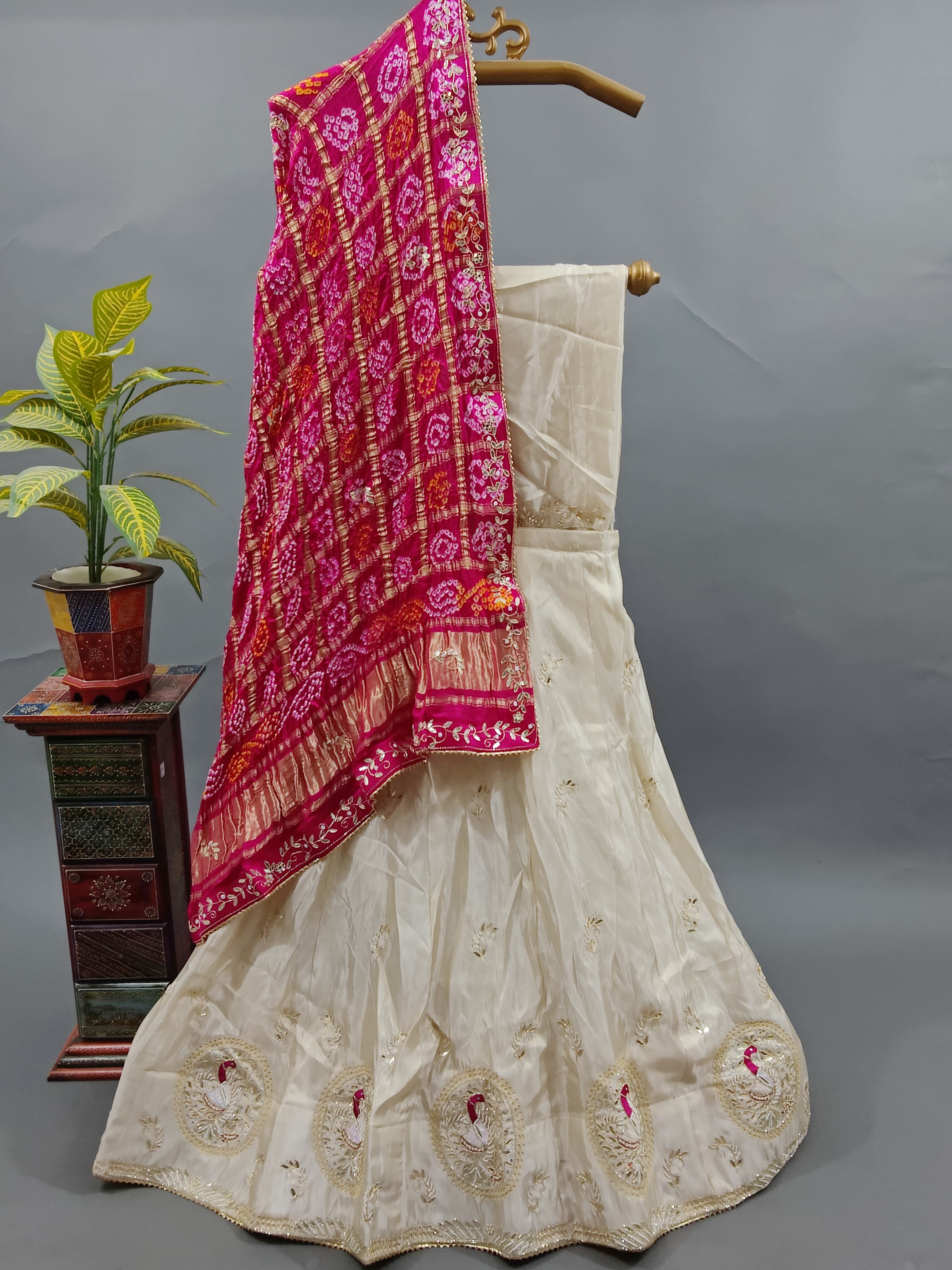 A traditional Indian lehenga with a dupatta, a pink and beige color 