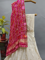 A traditional Indian lehenga with a dupatta, a pink and beige color 