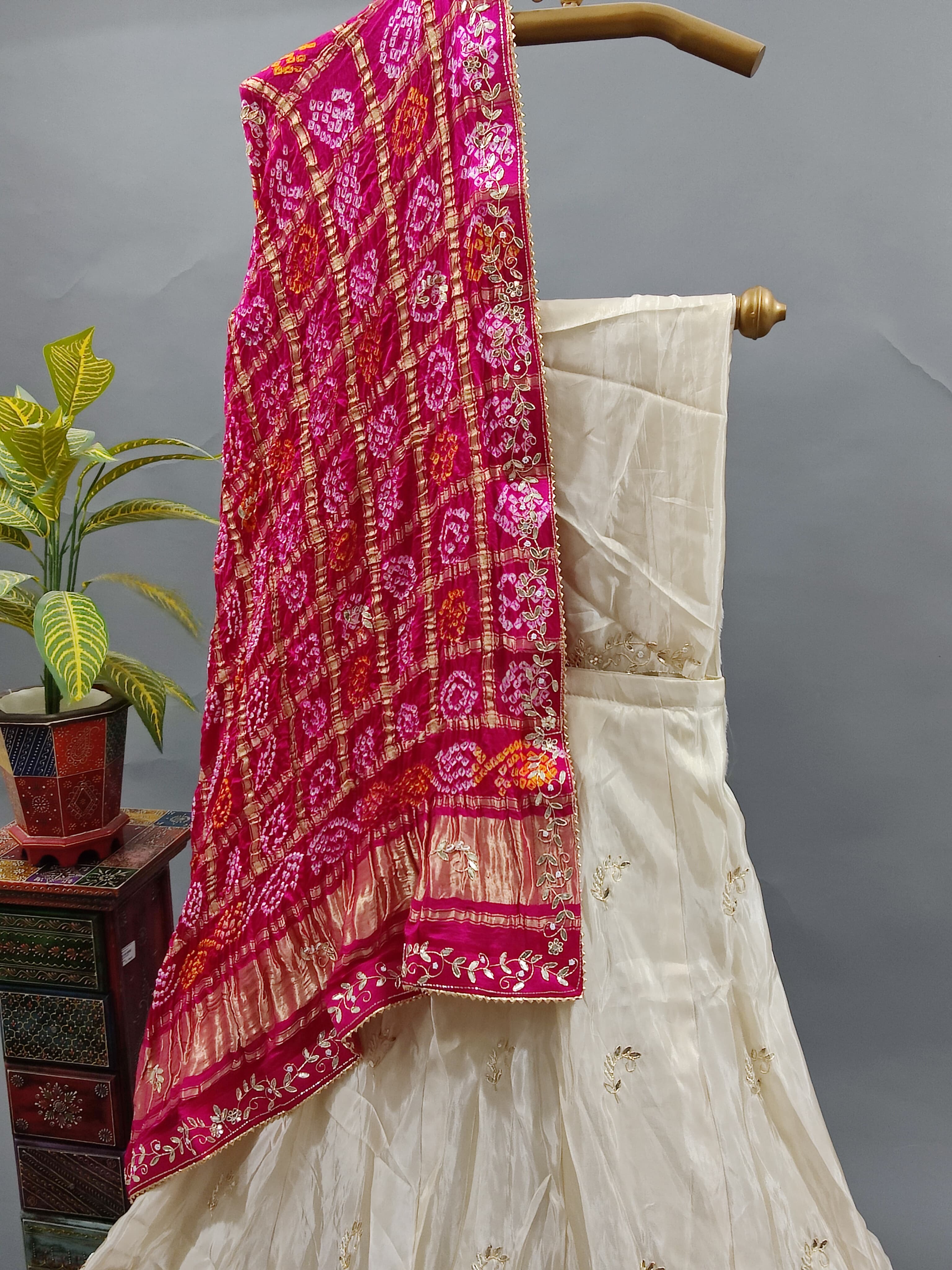 A traditional Indian lehenga with a dupatta, a pink and beige color 