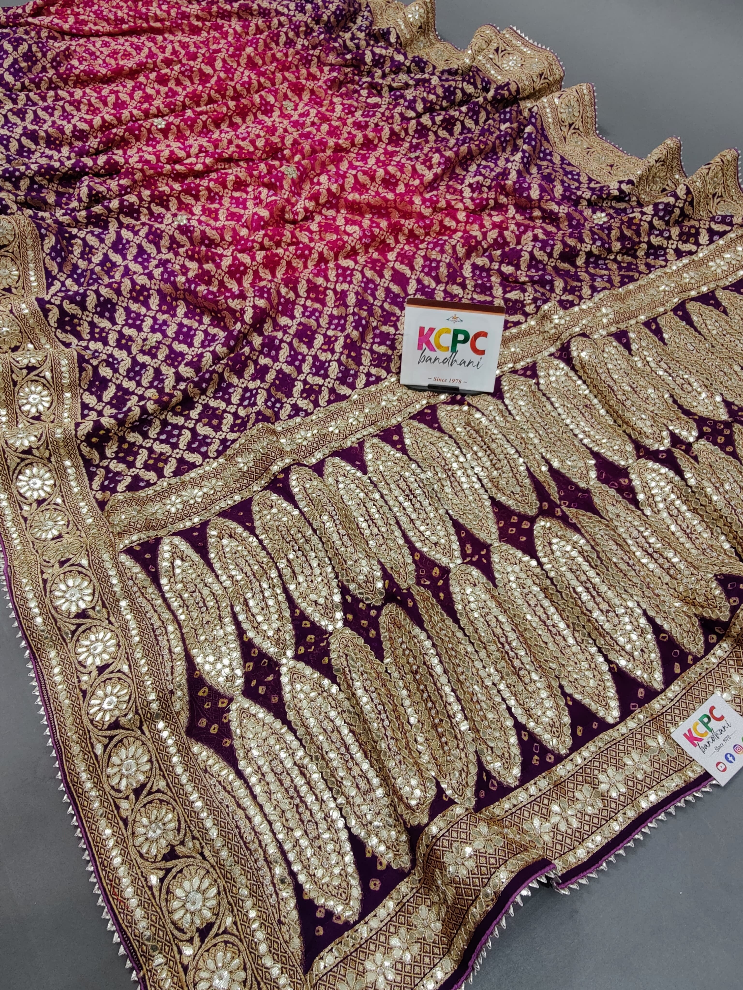 A designer pure khaddi georgette neemzari bandhej gotapatti zaridoji work saree in pink and purple colors 