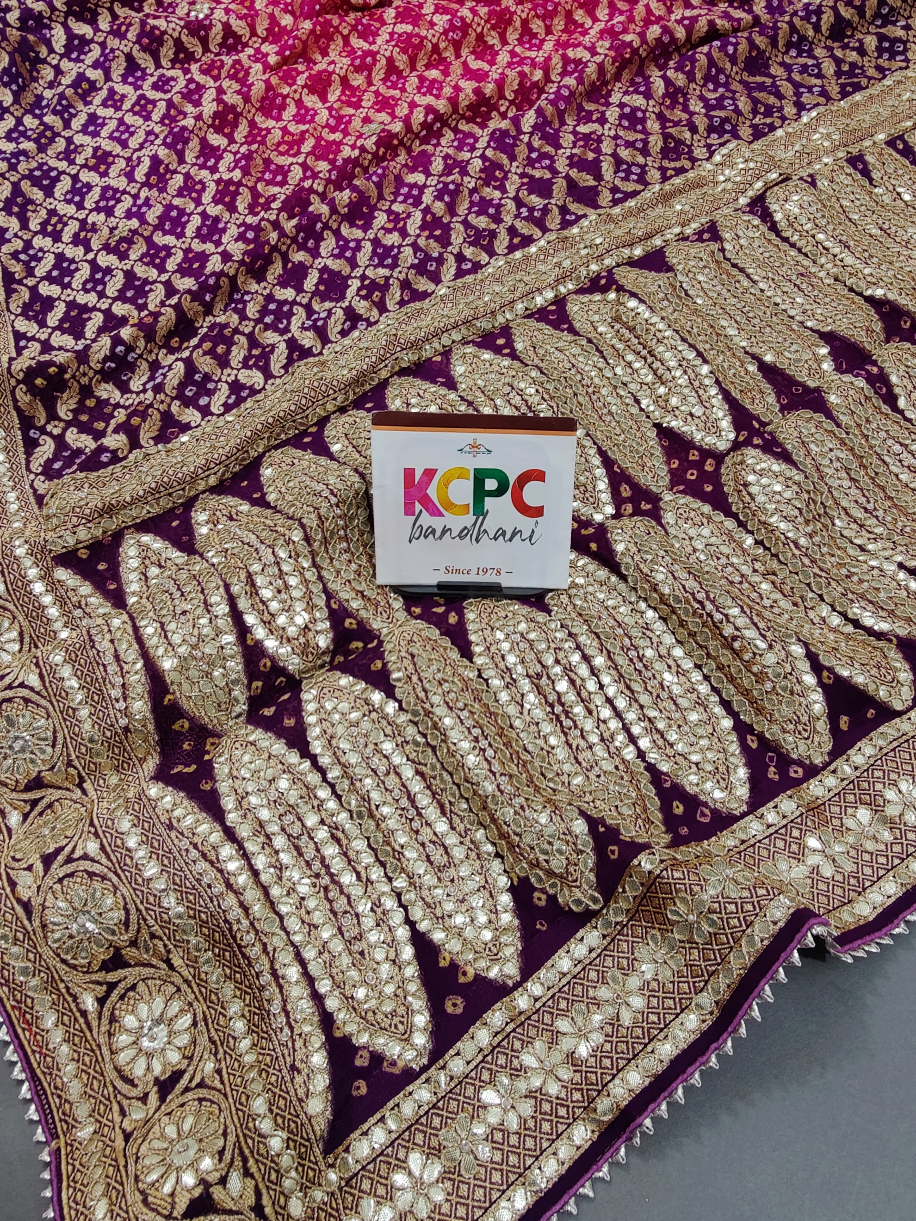 A designer pure khaddi georgette neemzari bandhej gotapatti zaridoji work saree in pink and purple colors 