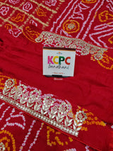 A red and gold silk saree with bandhani style and gota patti 