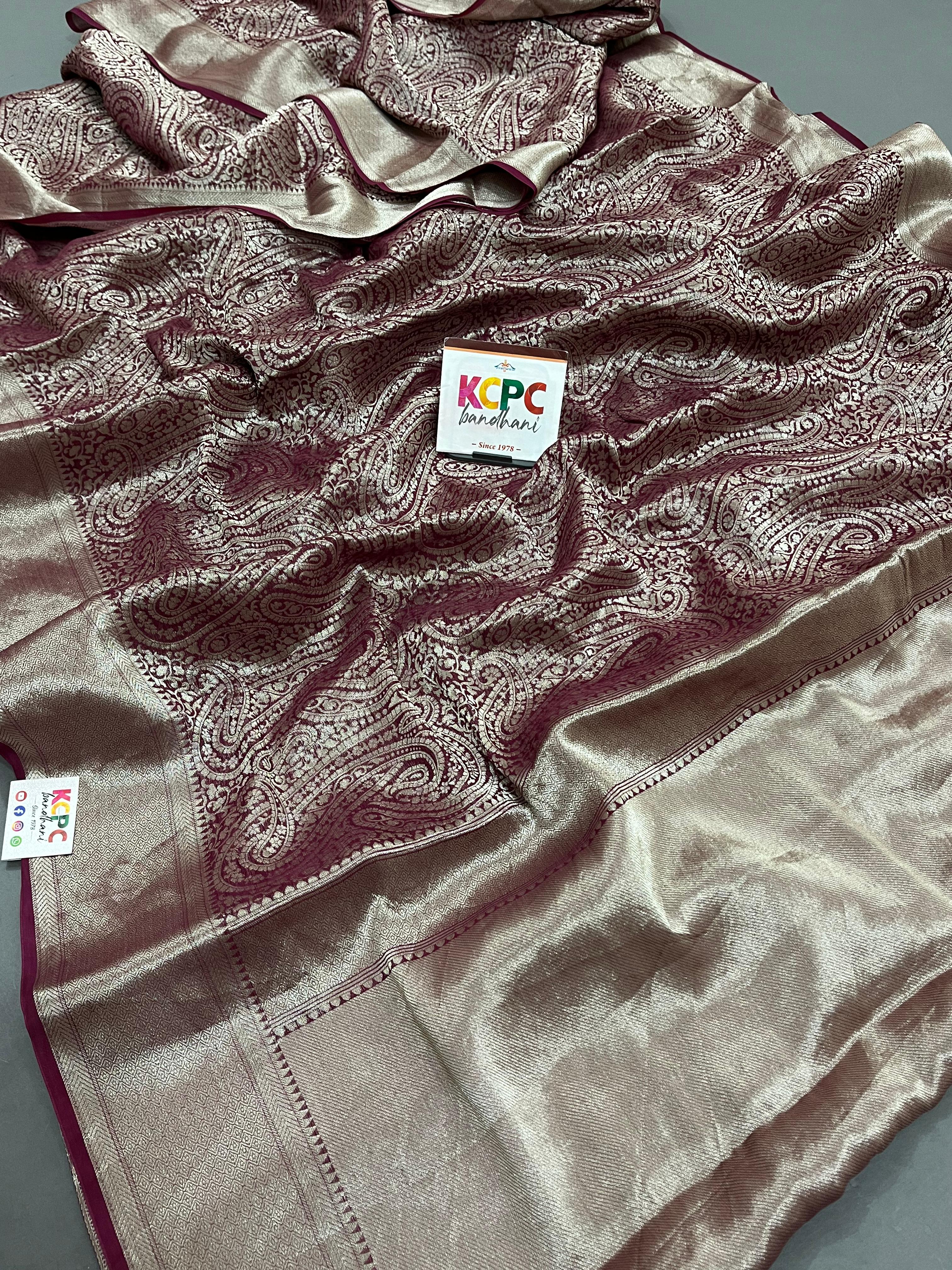 A folded KcPc brand pure khaddi georgette saree in wine color with golden banarasi zari weaving 