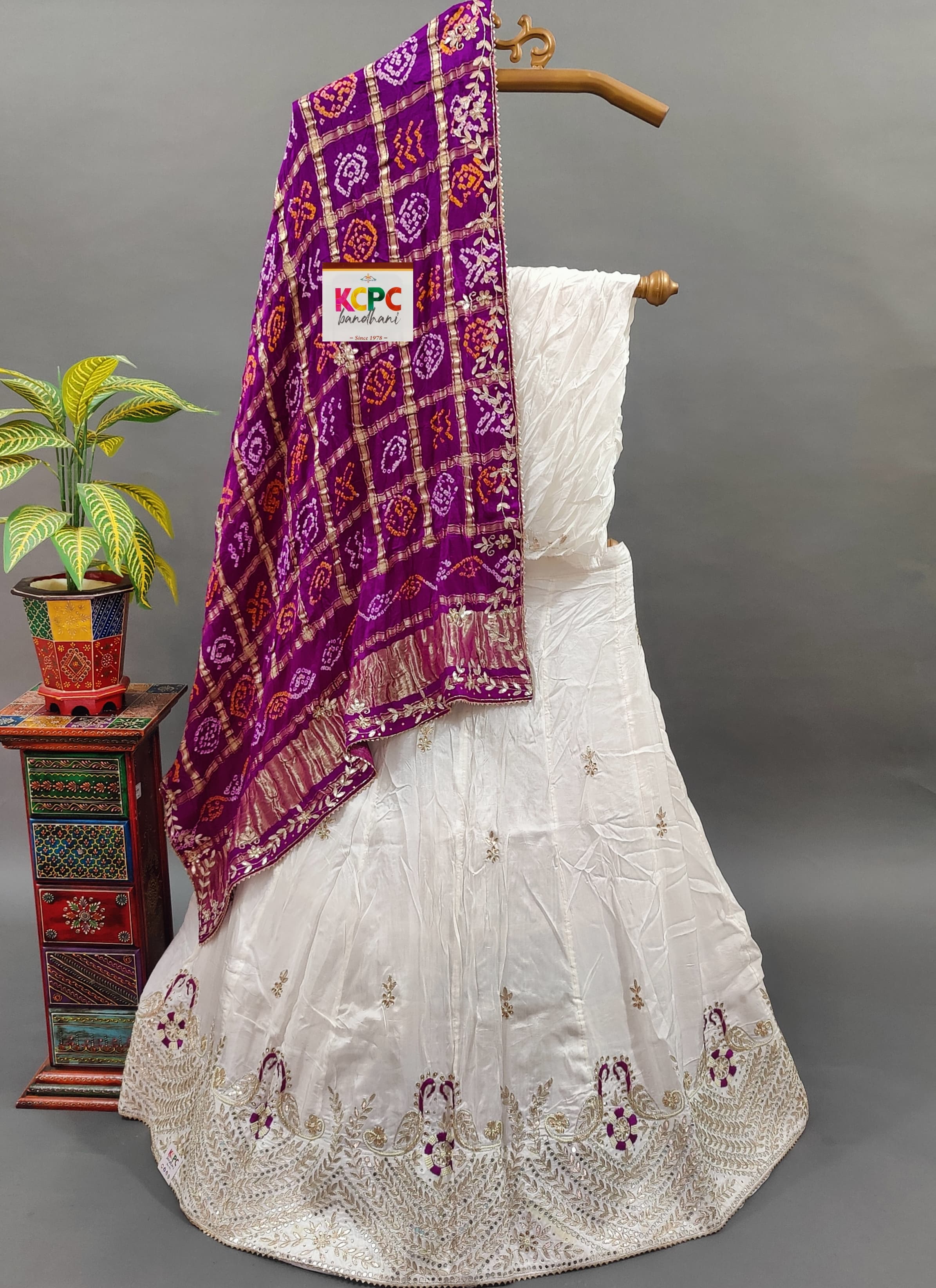 A traditional Indian lehenga set and purple dupatta with gotapatti work.