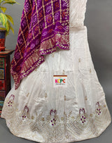 A traditional Indian lehenga set and purple dupatta with gotapatti work.