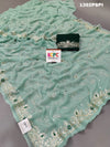 A traditional Rajputi saree in a light green color