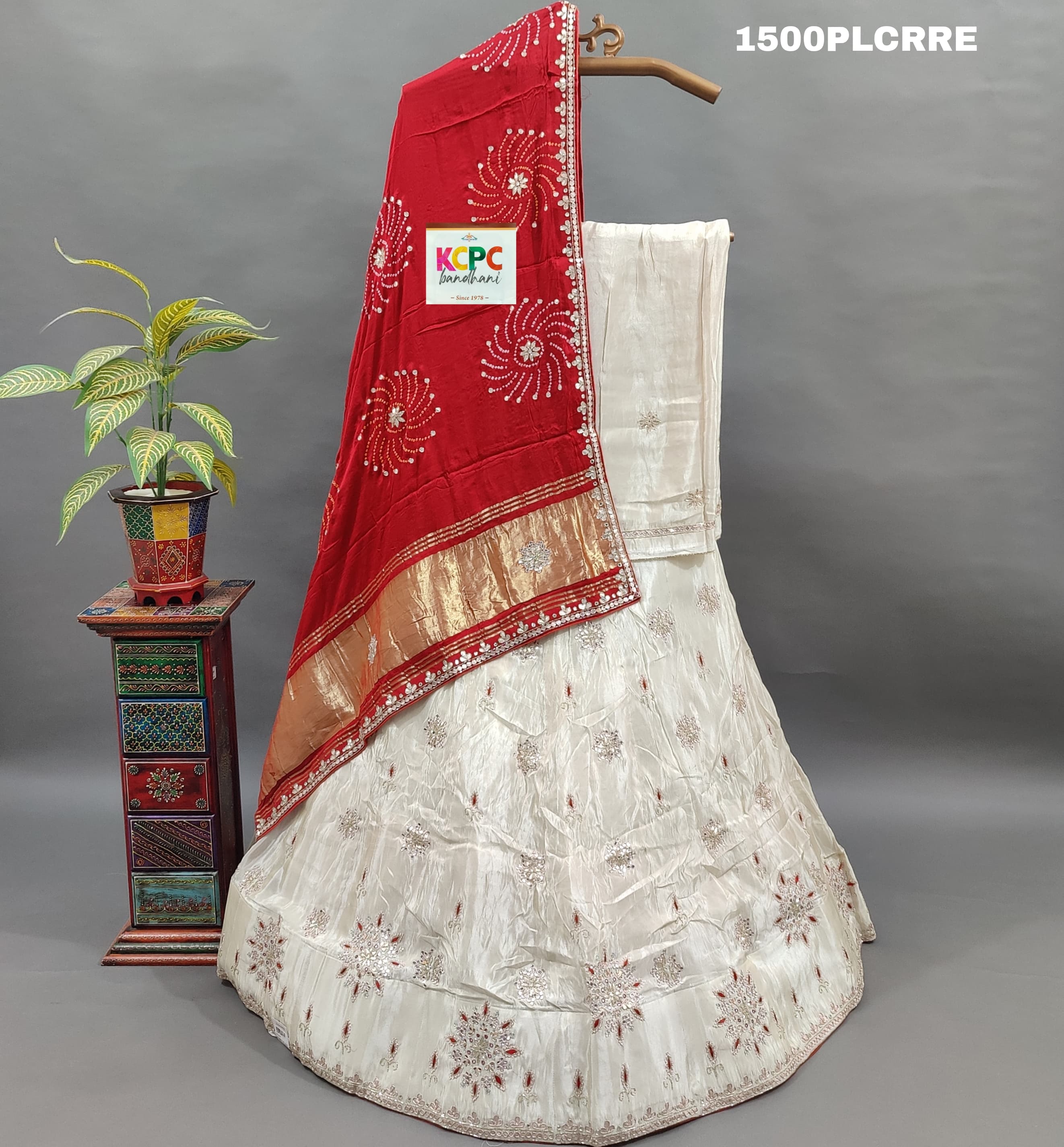 A red and white traditional lehenga with bandhani dupatta and zardoji gotapatti work