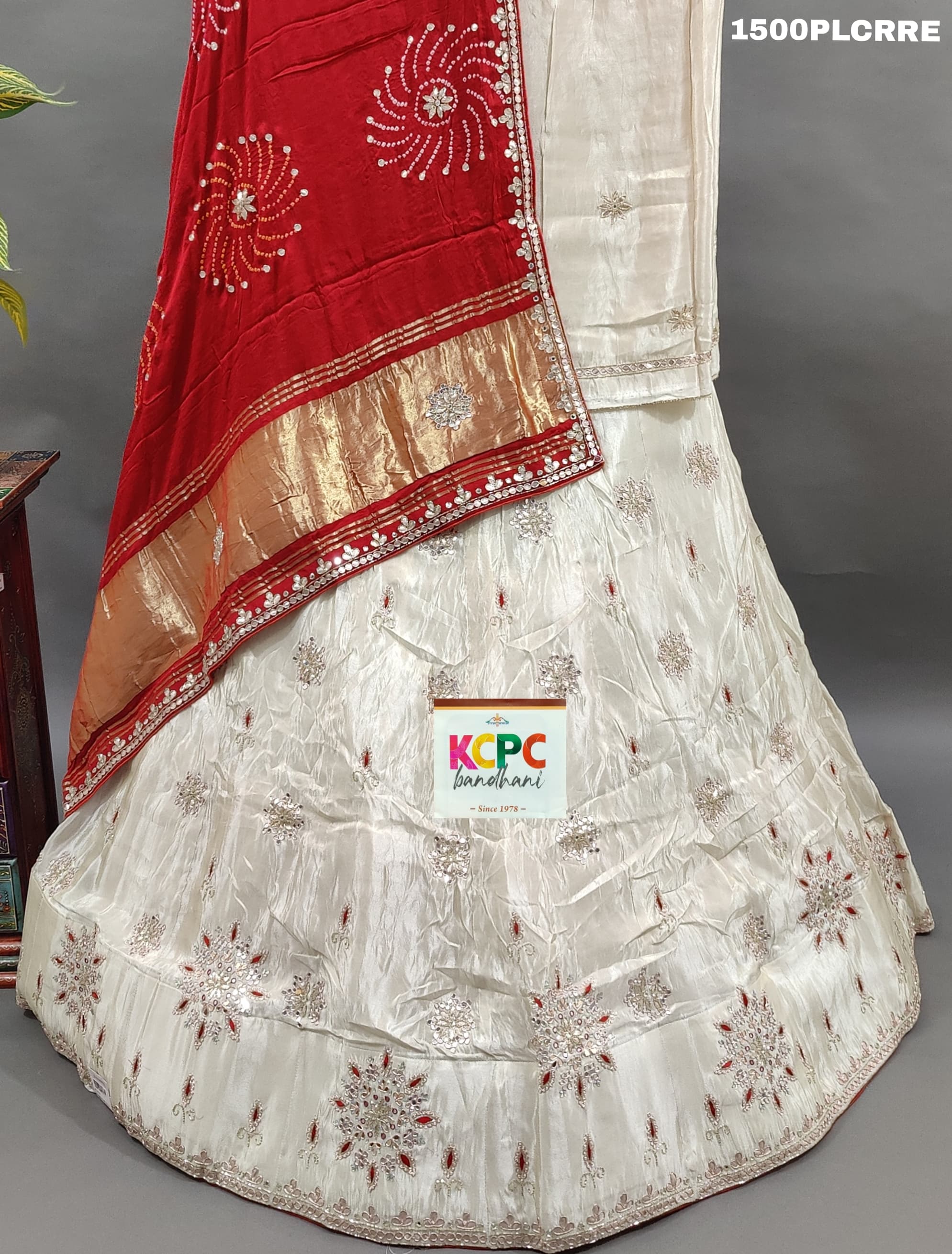 A red and white traditional lehenga with bandhani dupatta and zardoji gotapatti work