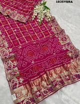 A pink and red silk saree with gota patti work and a floral embellishment 