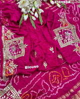 A pink and red silk saree with gota patti work and a floral embellishment 