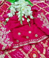 A pink saree with detailed golden and silver gotapatti work and a floral design