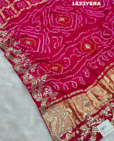A pink saree with detailed golden and silver gotapatti work and a floral design