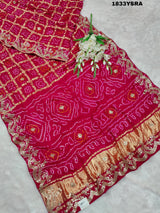 A pink saree with detailed golden and silver gotapatti work and a floral design