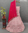 A pink traditional lehenga set with white beadwork and a red dupatta 