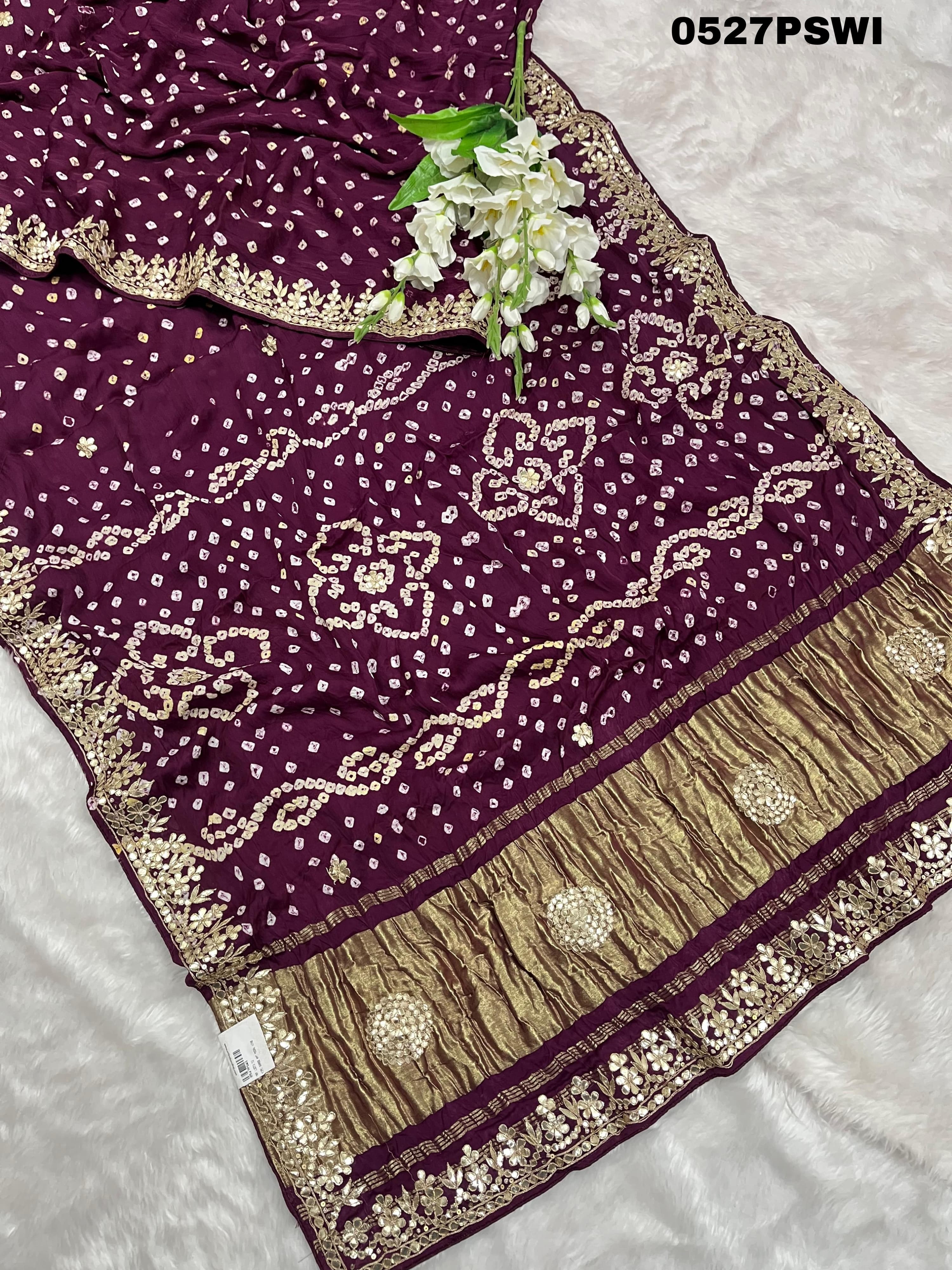 A purple modal silk bandhani saree with gota patti work and a floral embellishment 