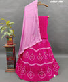 A traditional wear lehenga set with pink and white color bandhani style