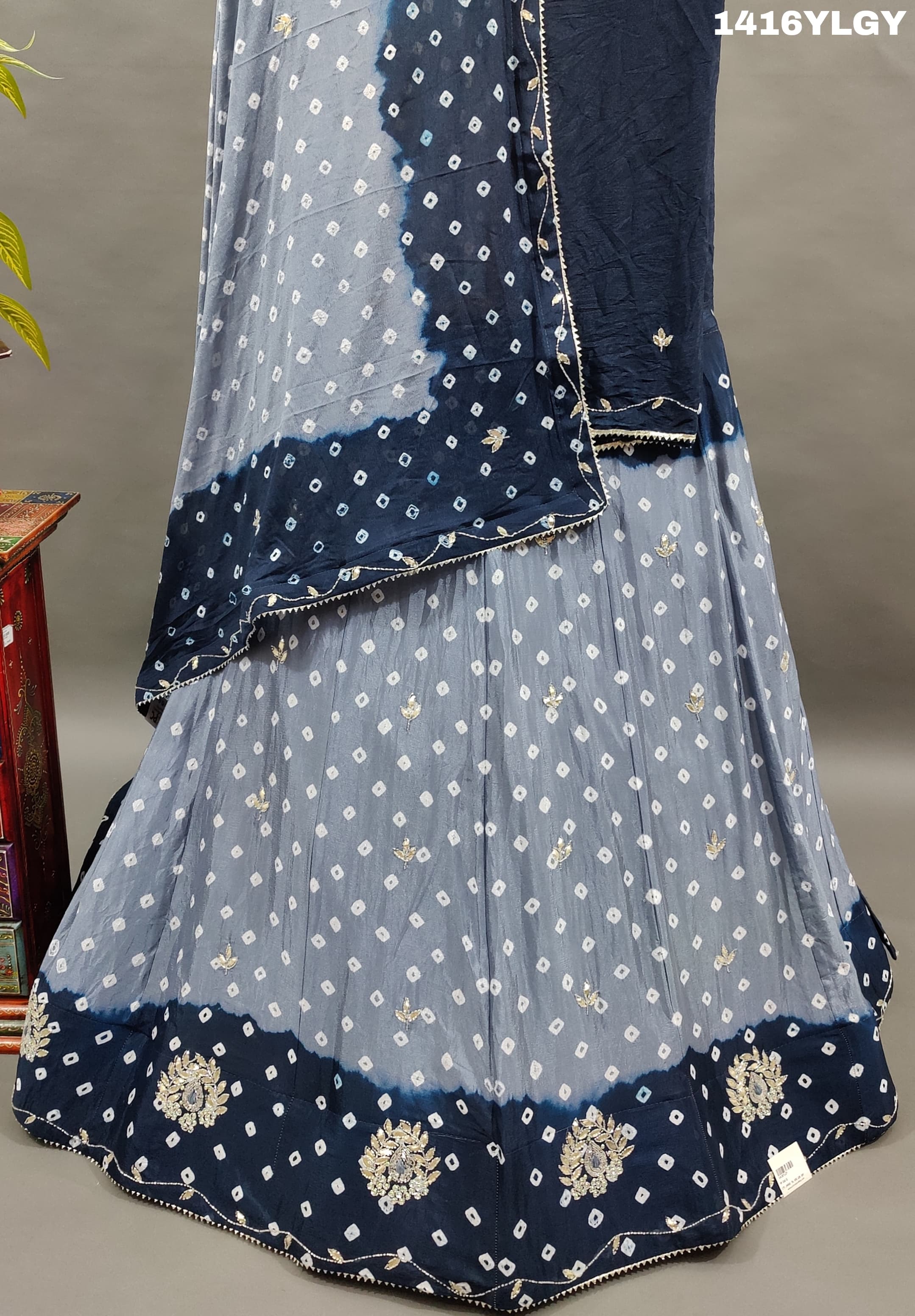A lehenga set with a blue and gray colordouble shade Bandhani cutdana work