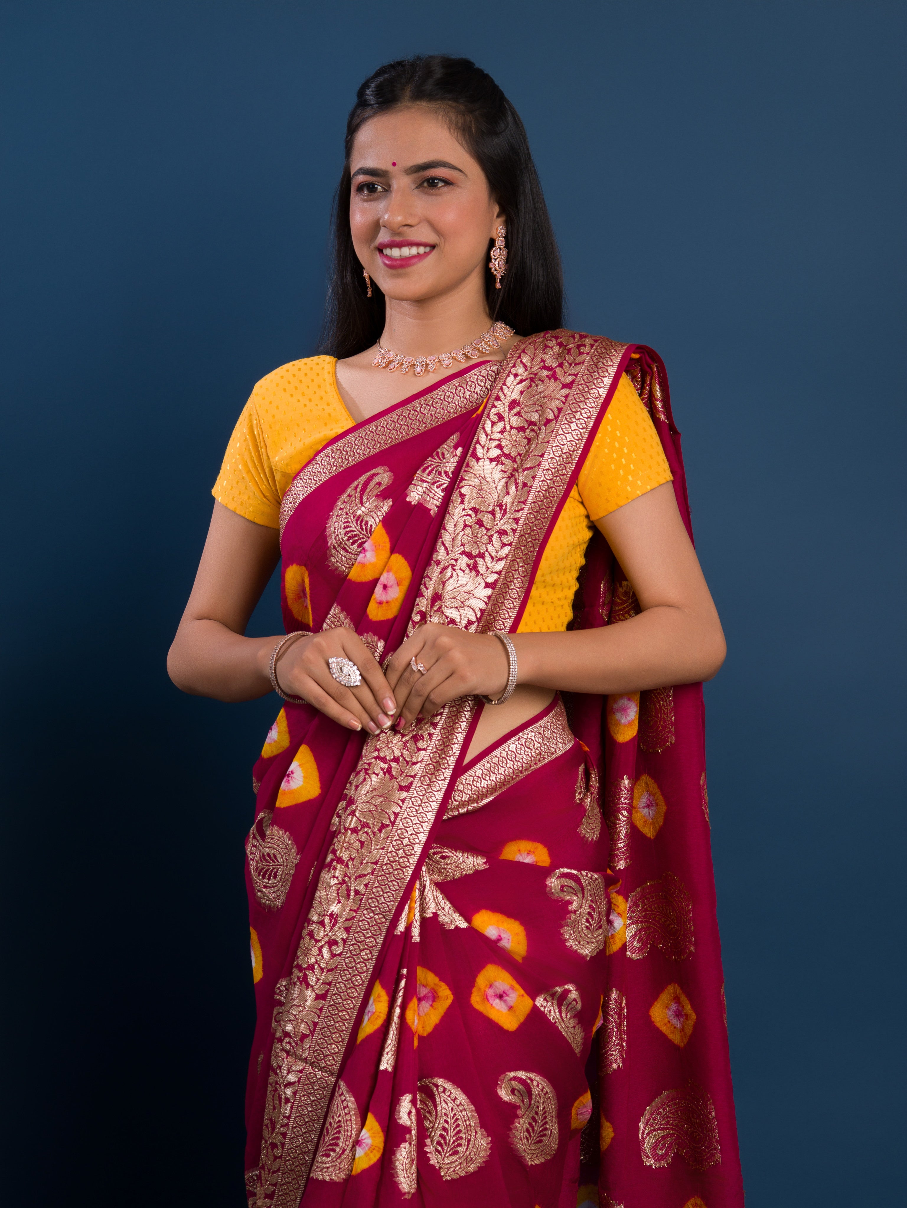 A maroon saree with gold patterns withDola Silk Bandhani Zari Weaving Work 