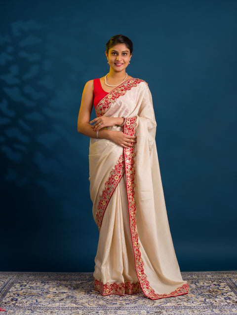A white chinon silk Bollywood style saree with embellishments and gotapatti work