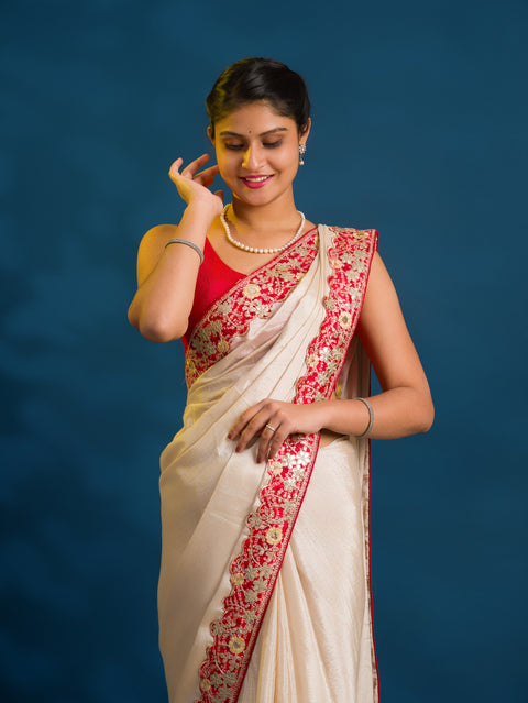 A white chinon silk Bollywood style saree with embellishments and gotapatti work
