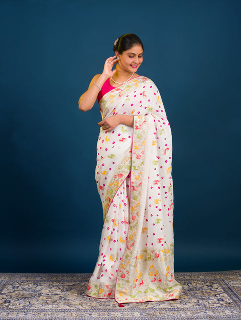 A Chinon silk saree with a Kalamkari style pattern, featuring a white base with multicolored floral designs and zari weaving details