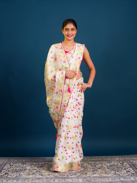 A Chinon silk saree with a Kalamkari style pattern, featuring a white base with multicolored floral designs and zari weaving details