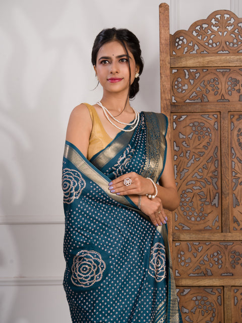 A blue saree with bandhani style embellishments and zari work