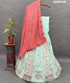 A lehenga set with a green and pink color cutdana work