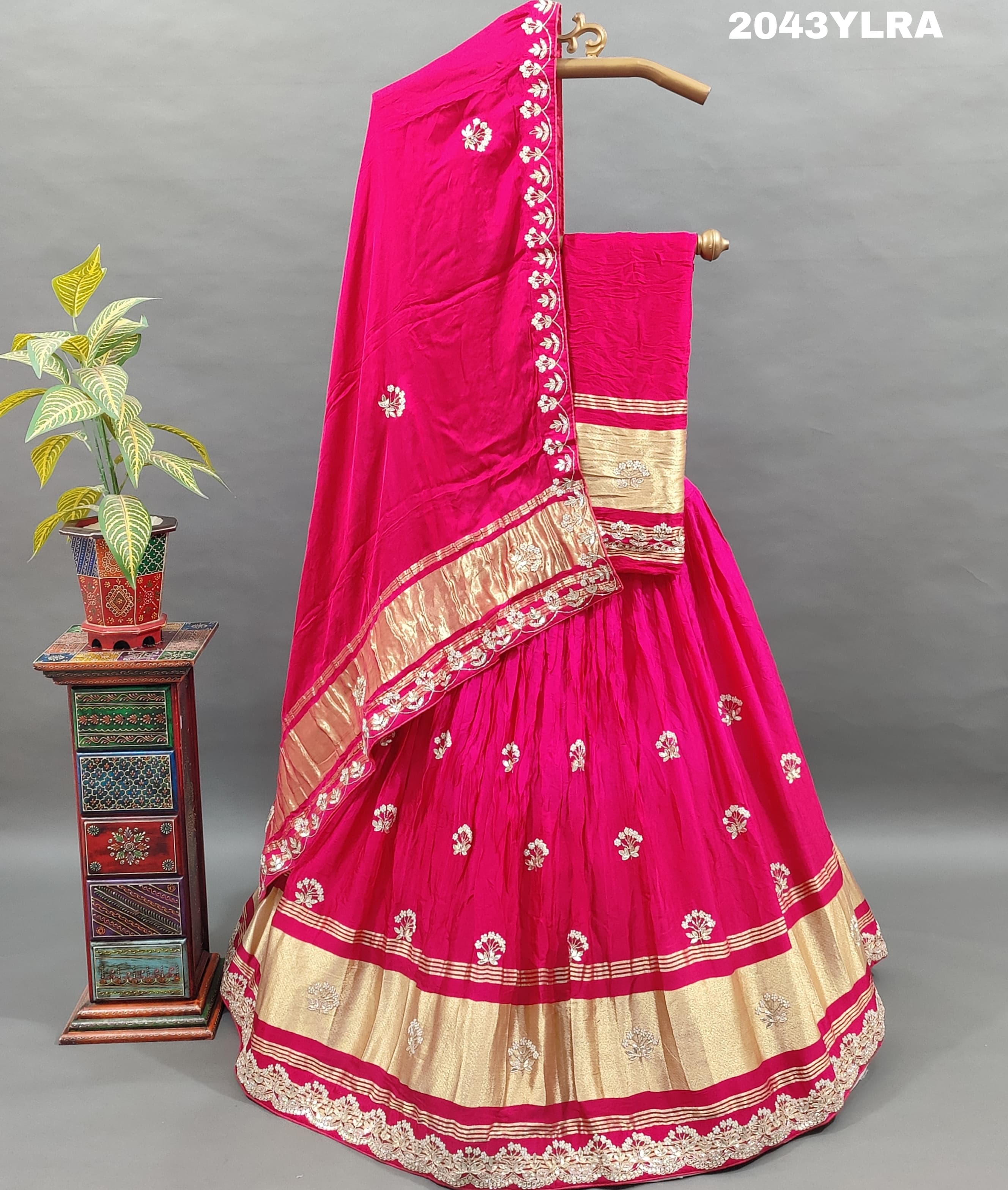 A pink Gaji silk lehenga with floral patterns and gold embellishments