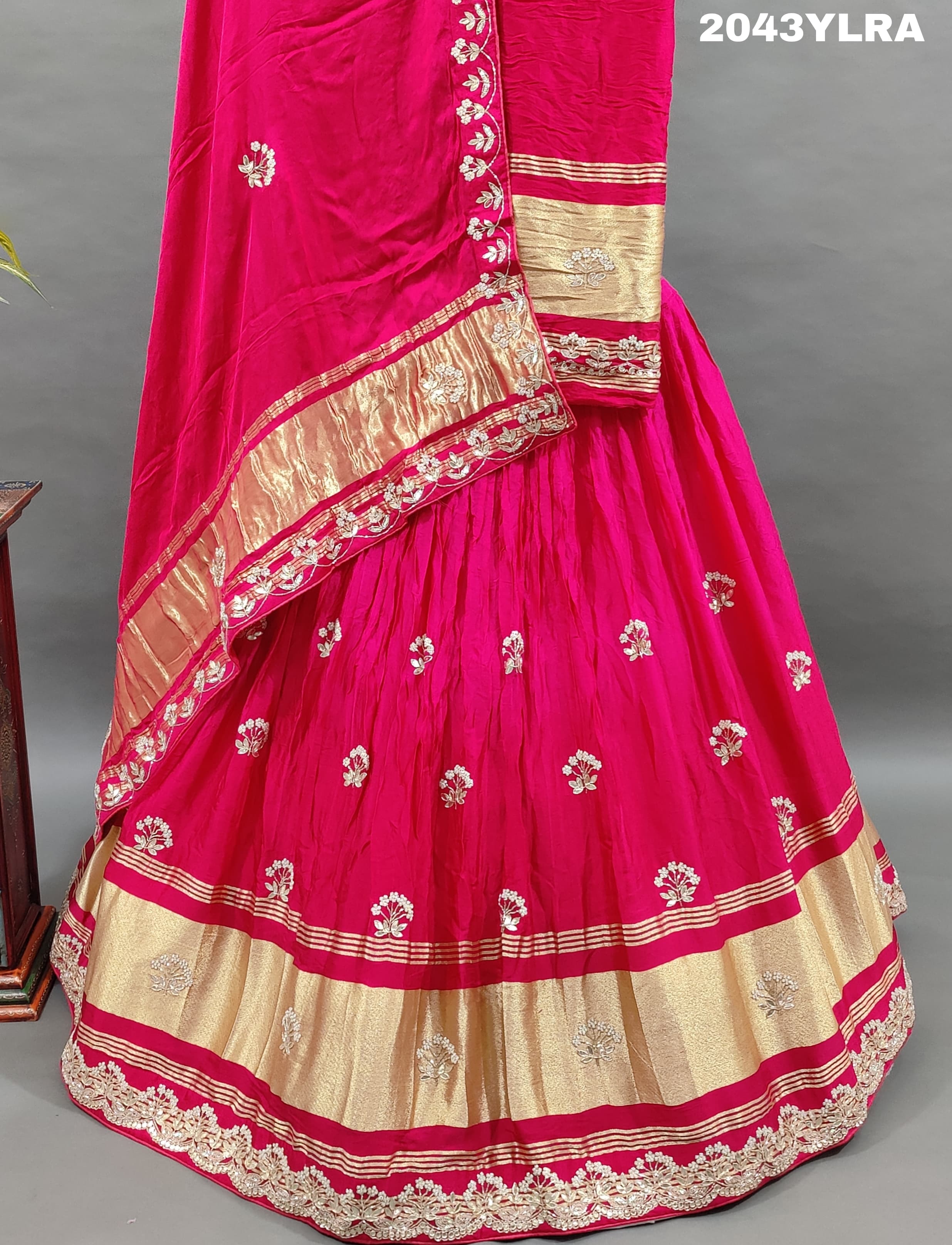 A pink Gaji silk lehenga with floral patterns and gold embellishments