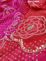 A pink and red traditional Indian saree with floral patterns and gota work.