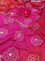 A pink and red traditional Indian saree with floral patterns and gota work.
