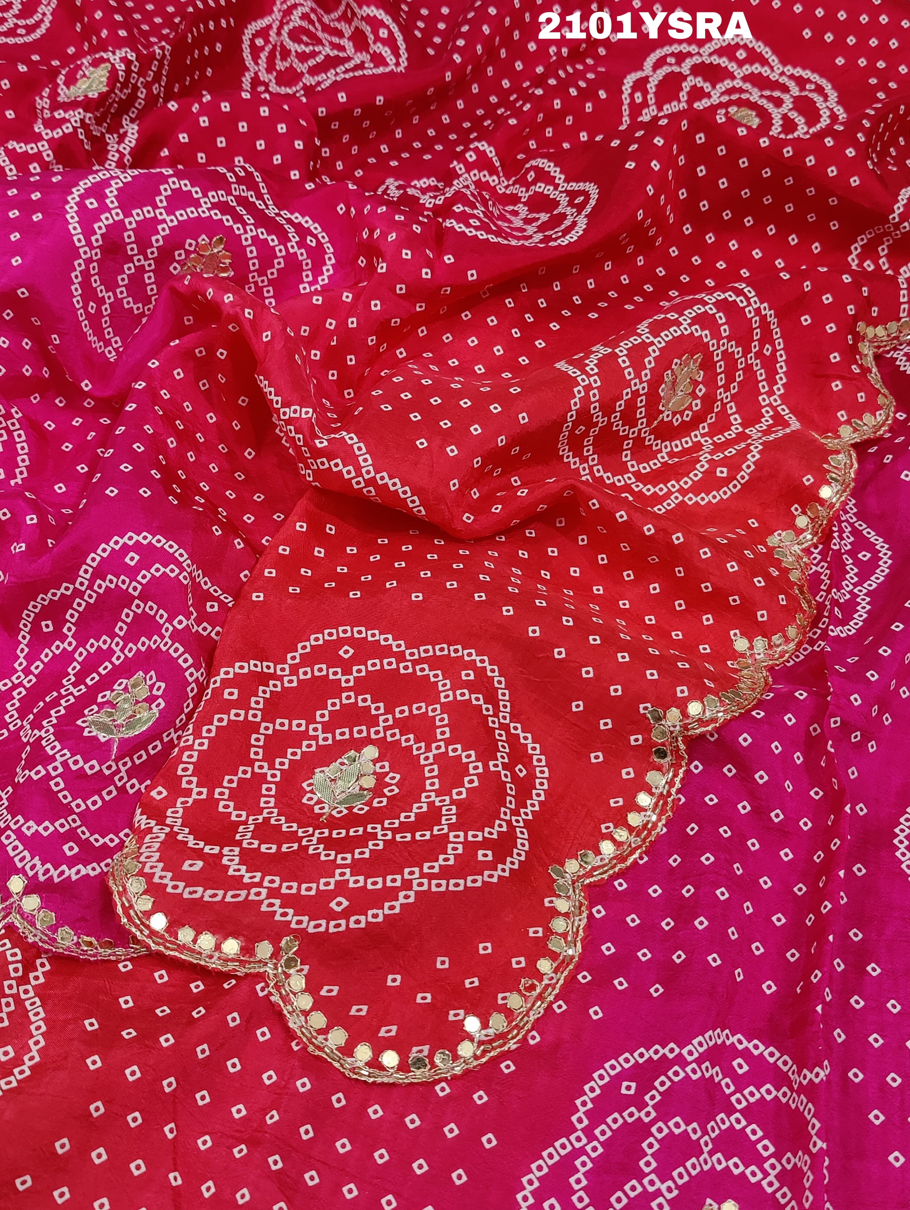 A pink and red traditional Indian saree with floral patterns and gota work.