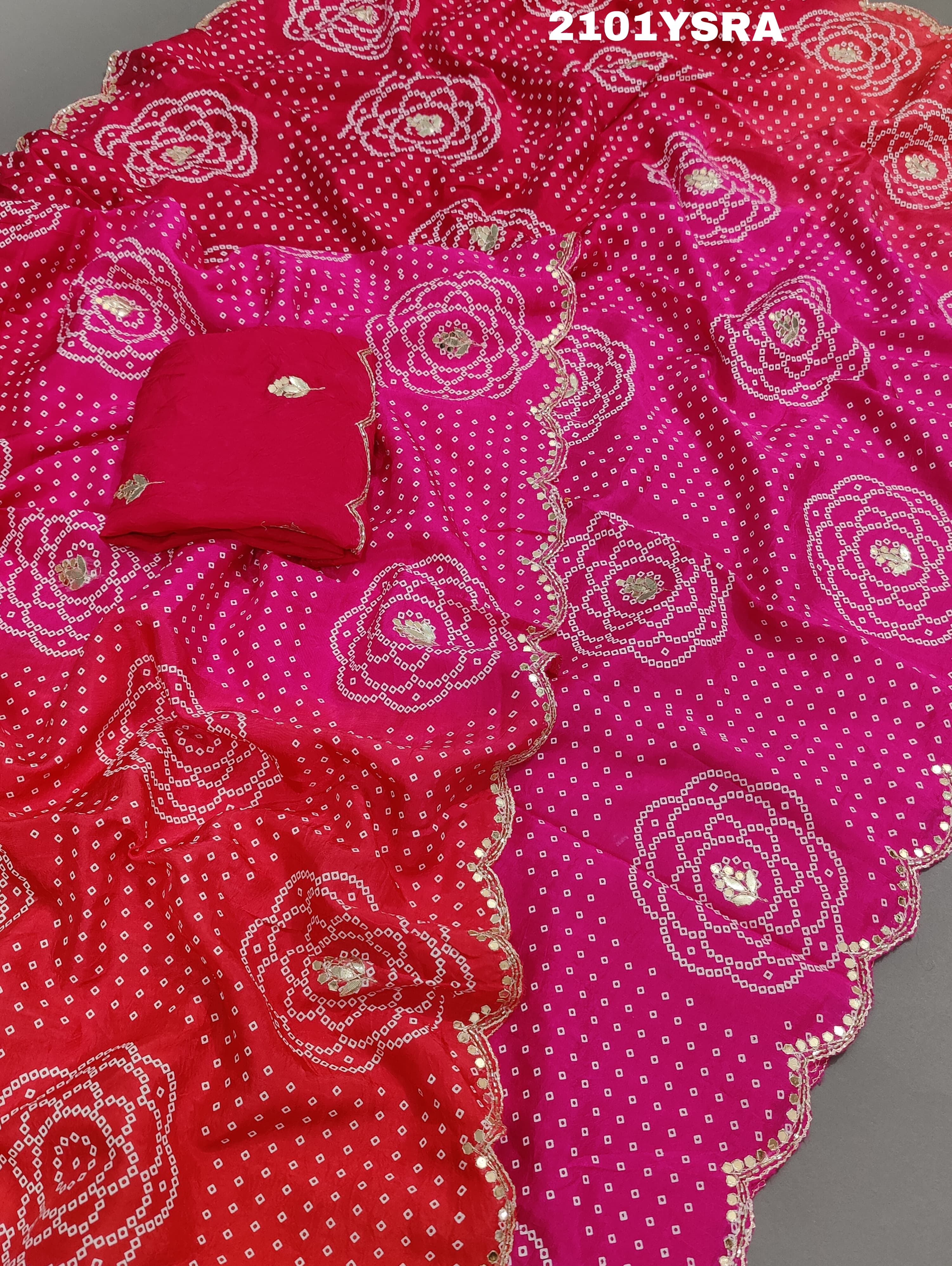 A pink and red traditional Indian saree with floral patterns and gota work.
