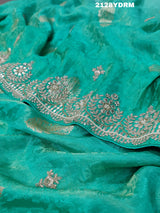 A green saree with red and silver paisley patterns and detailed embroidery, 