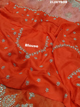 An orange saree with silver paisley pattern and floral gotapatti work, along with sequence embellishments.