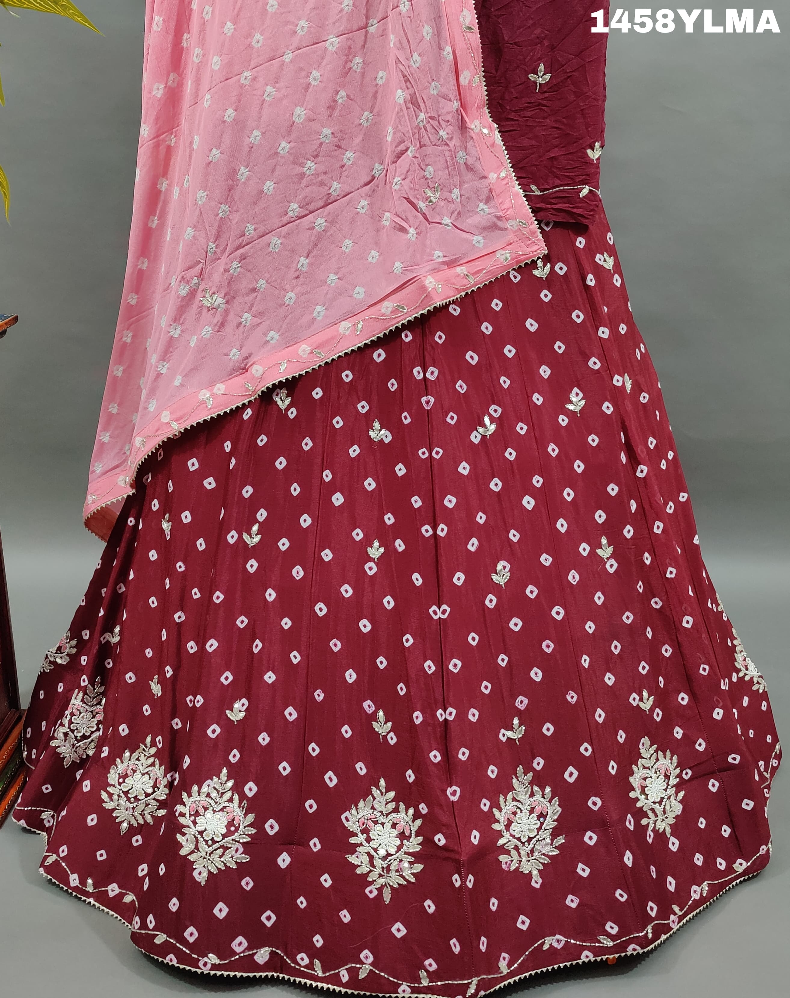 A traditional wear lehenga in maroon color with bandhani style 
