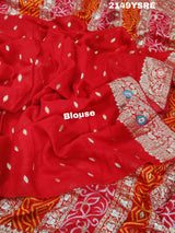 A red and orange Banarasi saree with geometric patterns and zari weaving details.