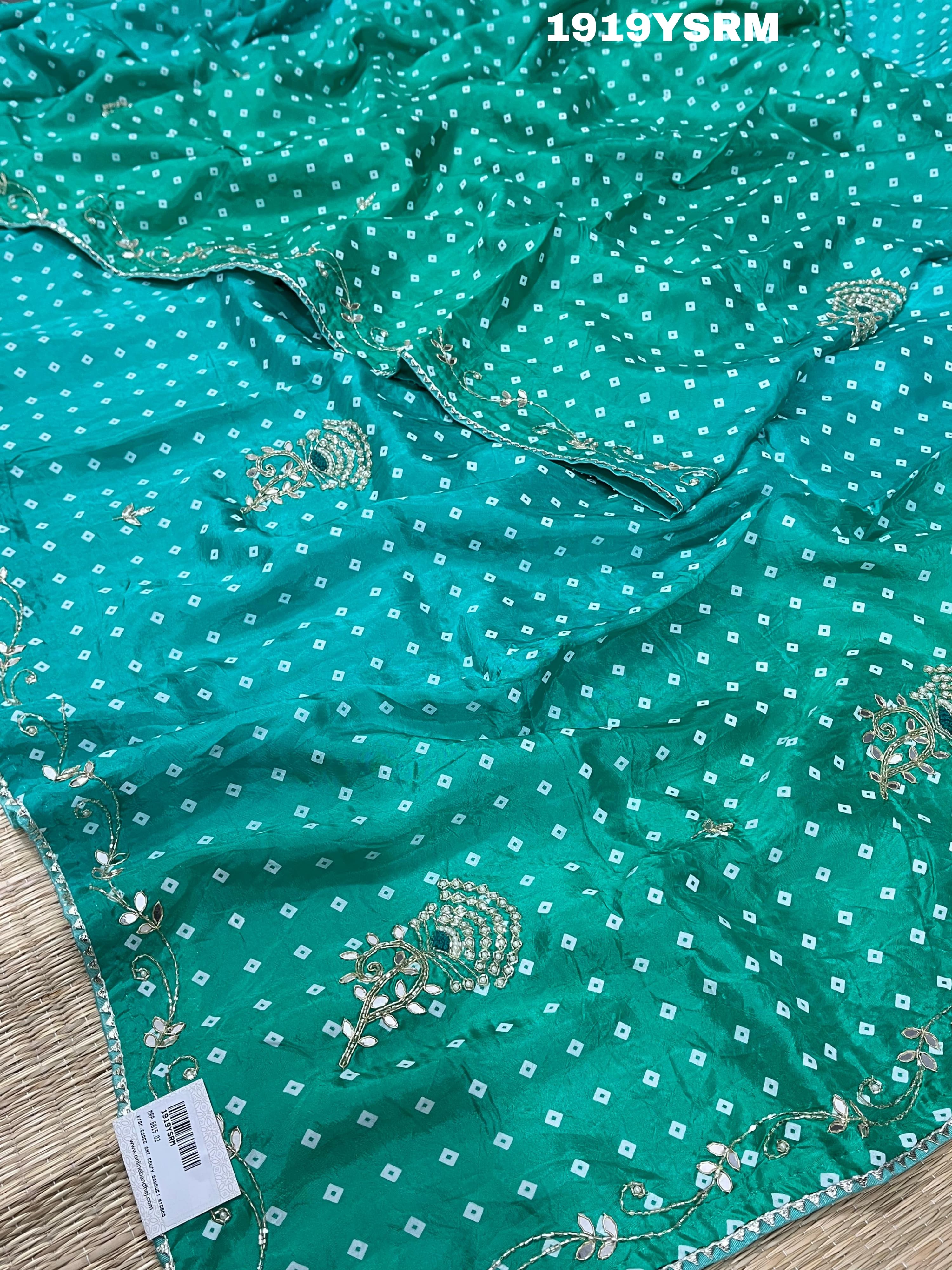 A green saree with bandhani pattern and cutdana work 