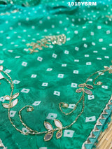A green saree with bandhani pattern and cutdana work 