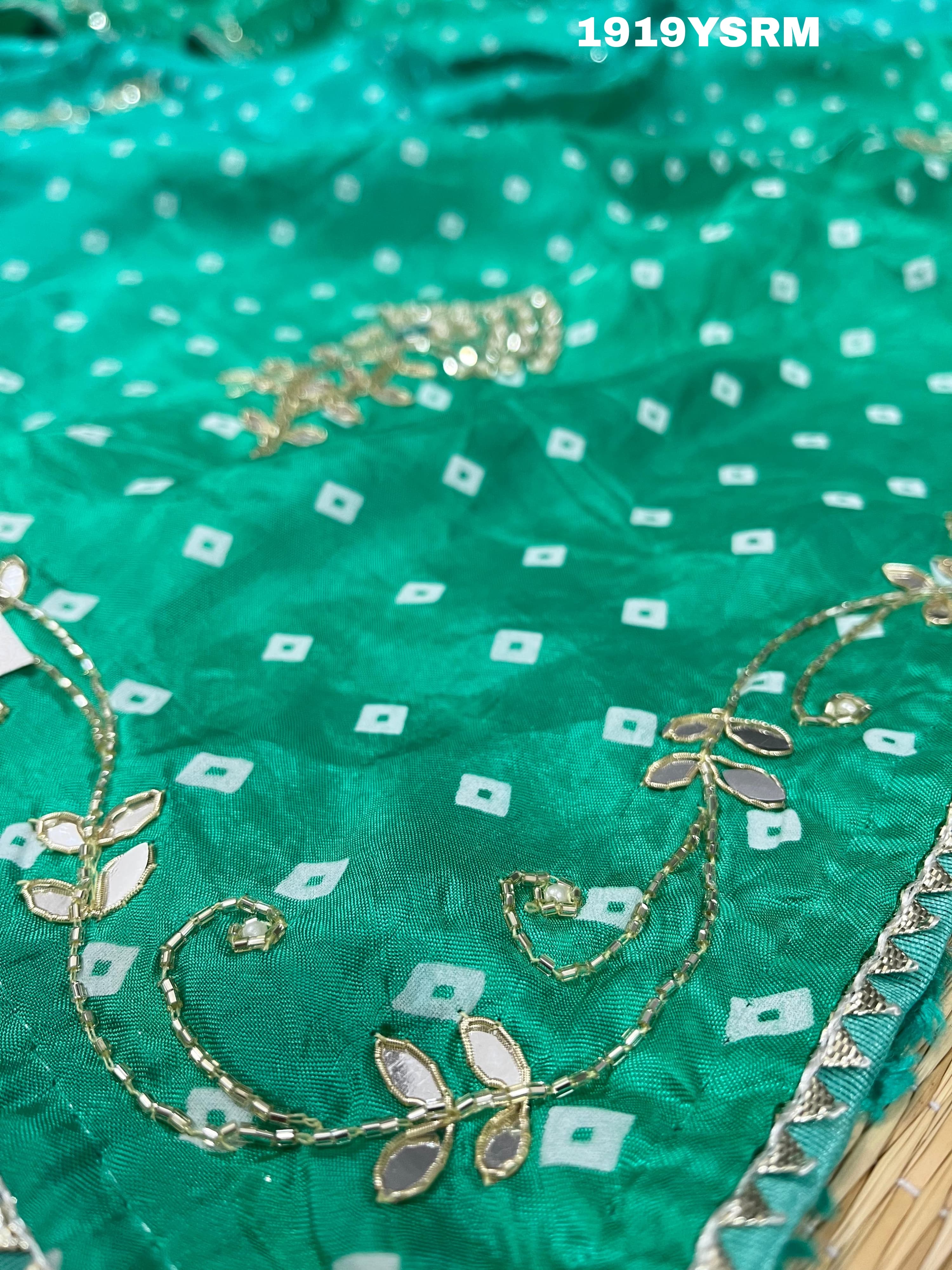 A green saree with bandhani pattern and cutdana work 