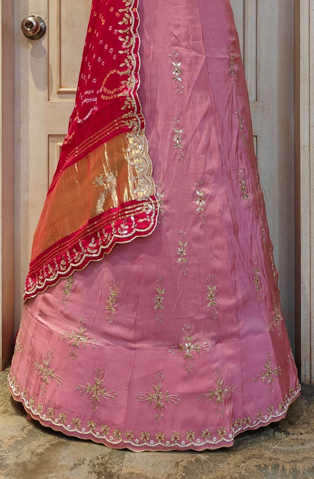 A traditional Indian lehenga with pink base color bandhani style 