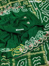 A green and silver pure gaji silk saree with bandhani pattern and gotapatti handwork, displayed on a surface.