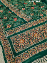 A green saree with red bandhej patterns and royal aari work, along with real mirror work on the border.