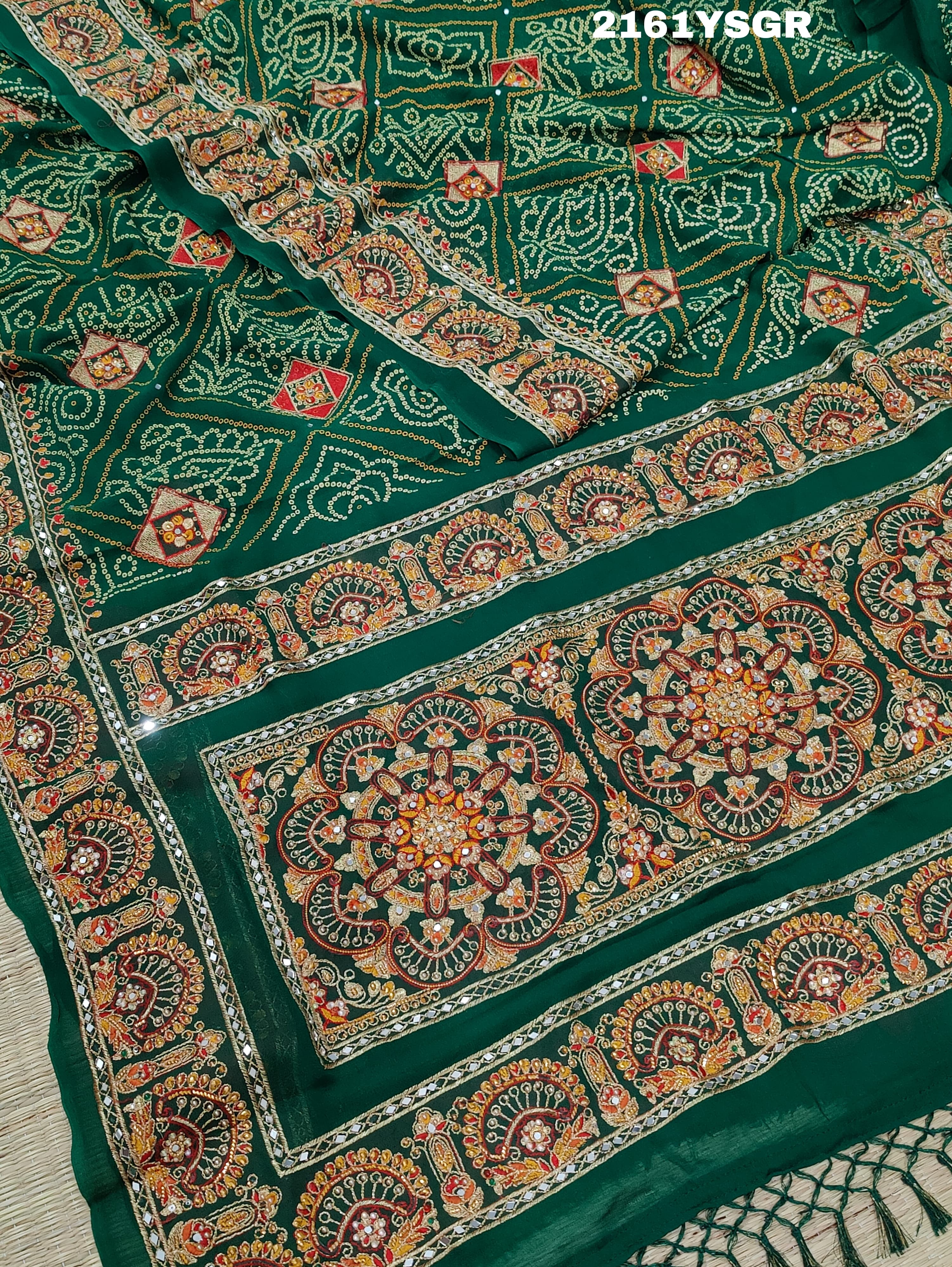A green saree with red bandhej patterns and royal aari work, along with real mirror work on the border.