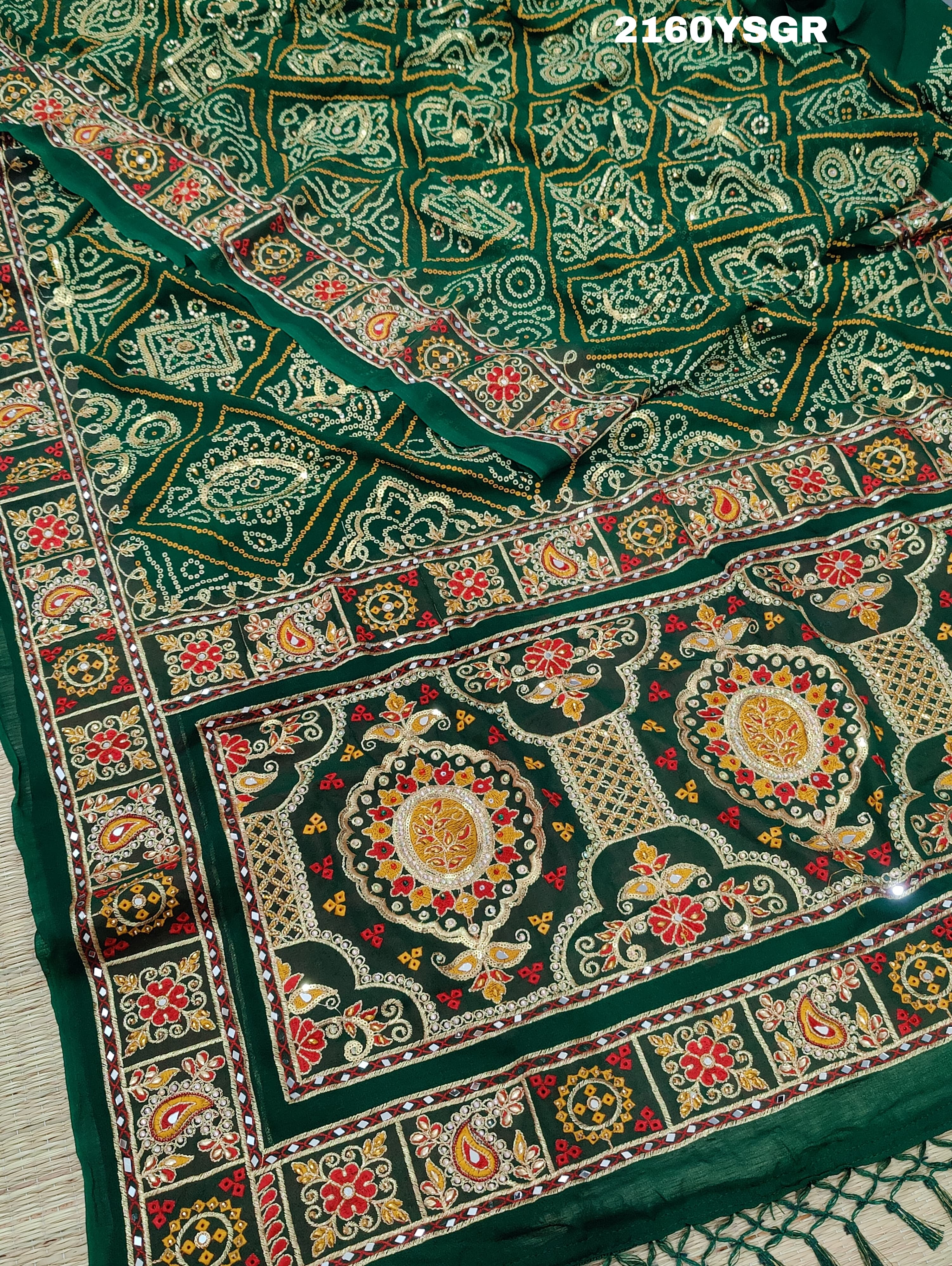 A green bandhej saree with royal aari and real mirror work, displayed on a surface.