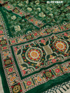 A green saree with traditional Jaipuri Rajwadi style embroidery and bandhani patterns, including real vintage mirror work.