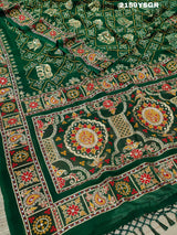 A green saree with traditional Jaipuri Rajwadi style embroidery and bandhani patterns, including real vintage mirror work.