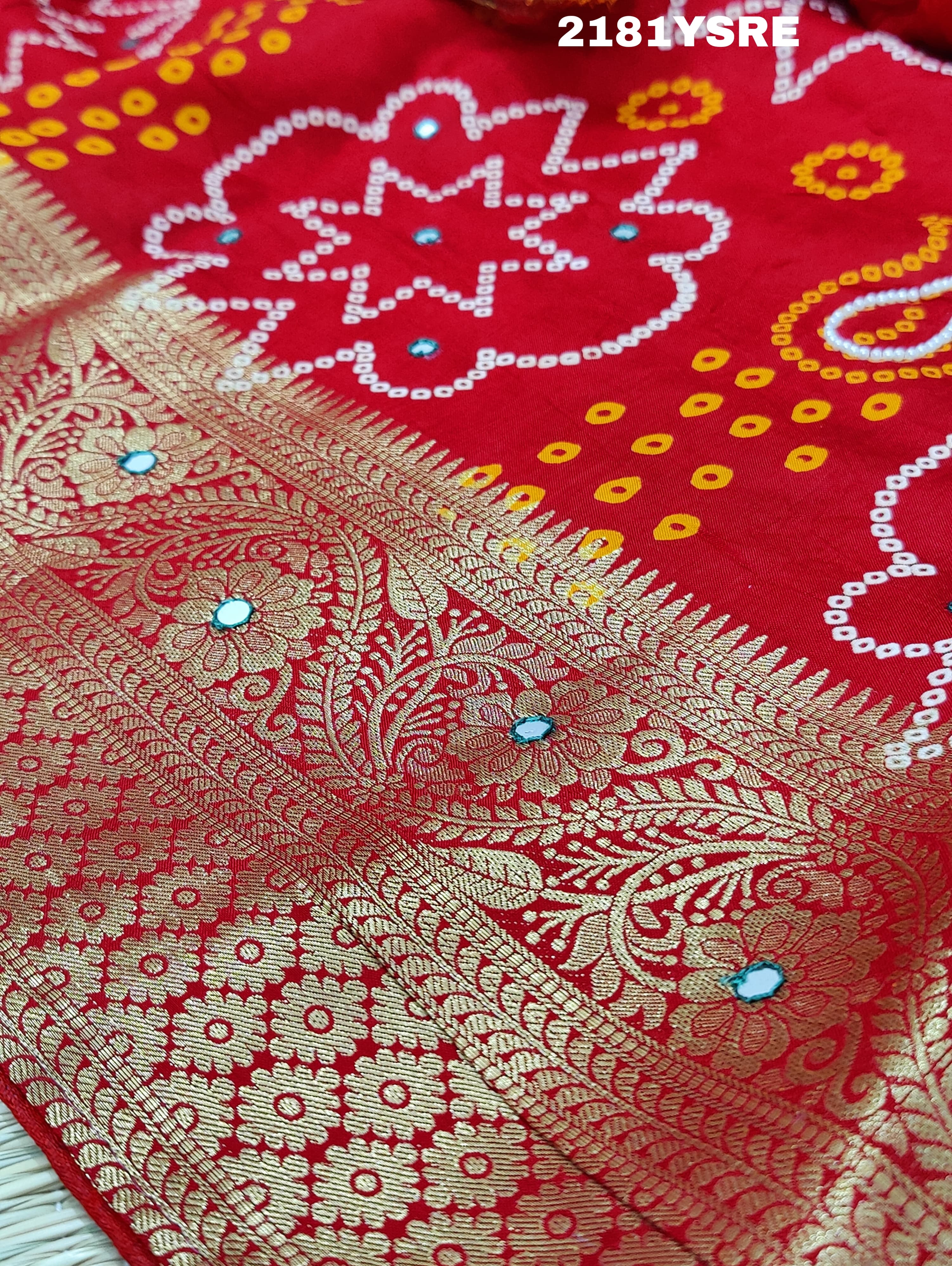 A red and silver bandhani style silk saree with mirror handwork, including floral patterns and a traditional design.